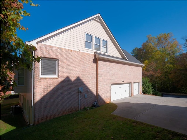 view of home's exterior with a yard, cooling unit, and a garage