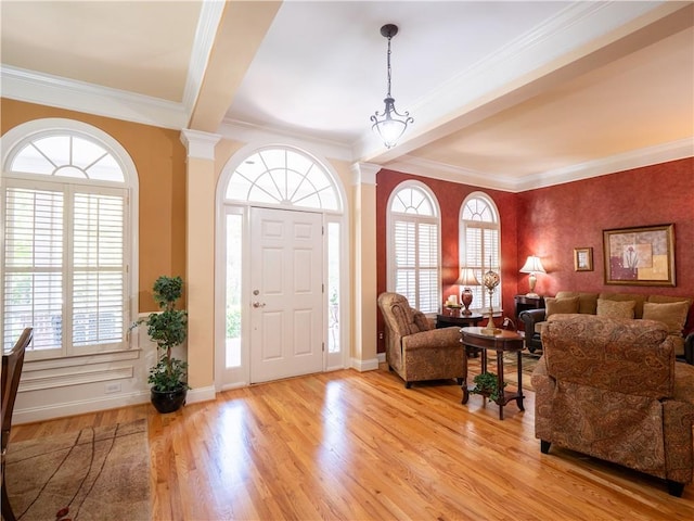 foyer entrance with a wealth of natural light, crown molding, and light hardwood / wood-style flooring