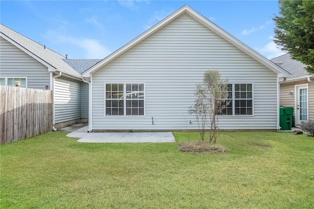 rear view of property with a yard and fence