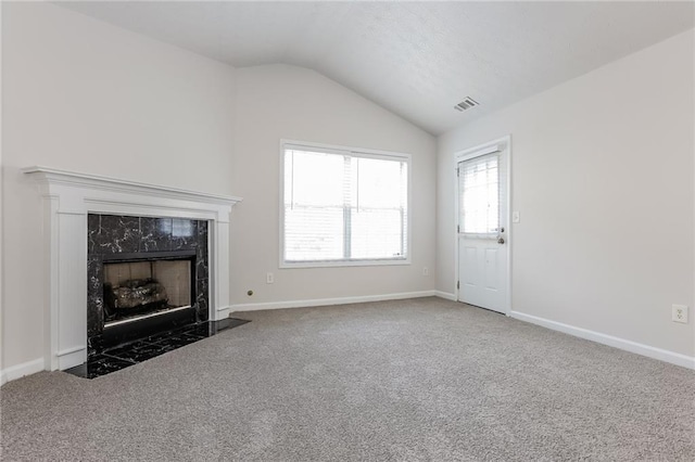 unfurnished living room with a fireplace, visible vents, carpet flooring, vaulted ceiling, and baseboards