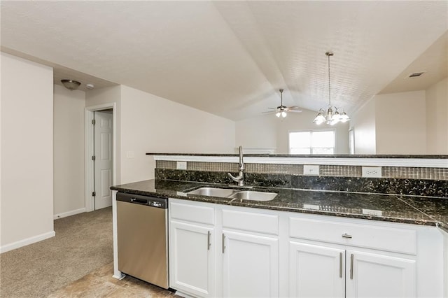 kitchen featuring dark stone counters, white cabinets, dishwasher, light colored carpet, and a sink