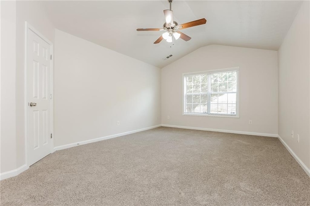 empty room featuring ceiling fan, visible vents, baseboards, vaulted ceiling, and carpet