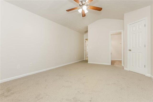 unfurnished bedroom with light carpet, ceiling fan, baseboards, and vaulted ceiling