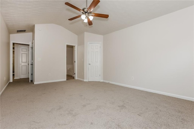 unfurnished bedroom featuring light carpet, visible vents, baseboards, and lofted ceiling