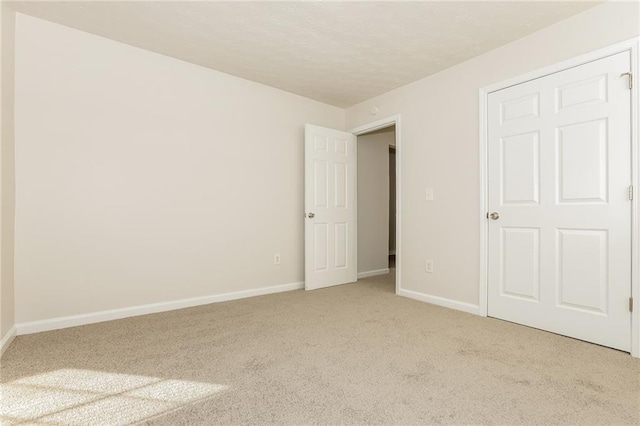 interior space featuring carpet floors, baseboards, and a textured ceiling