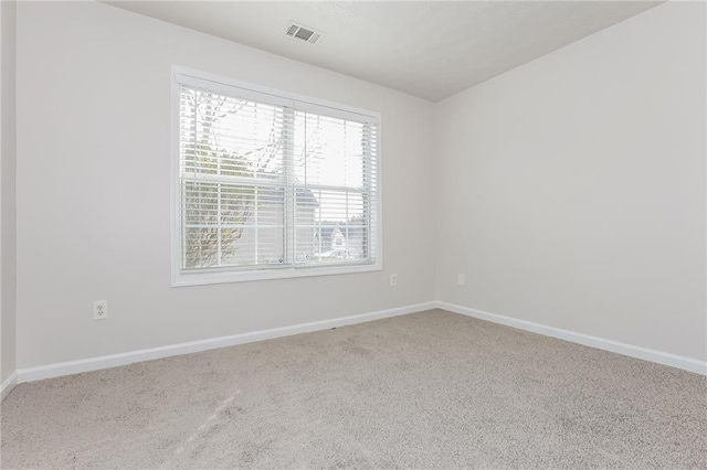 unfurnished room with baseboards, visible vents, and carpet flooring