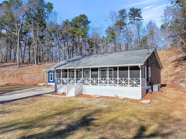 view of front of property featuring a front lawn and a sunroom