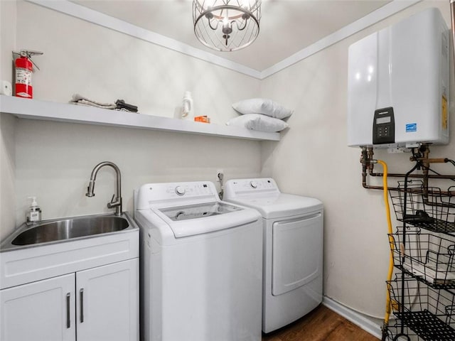 laundry area with sink, crown molding, cabinets, tankless water heater, and separate washer and dryer