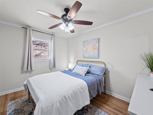 bedroom featuring hardwood / wood-style flooring, crown molding, and ceiling fan