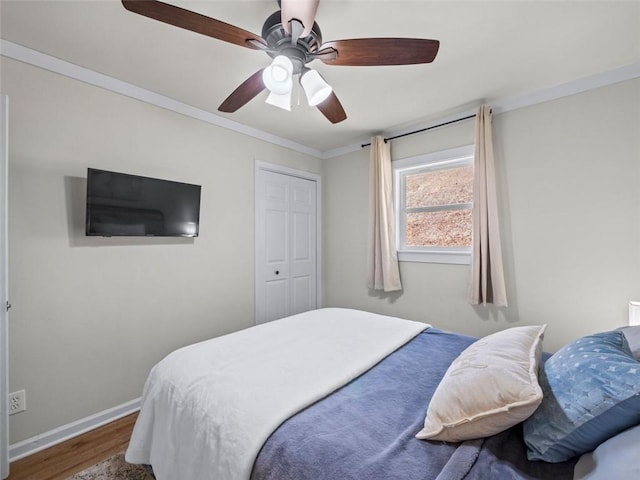 bedroom featuring hardwood / wood-style flooring, ornamental molding, and ceiling fan