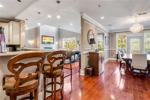 interior space with a healthy amount of sunlight, hanging light fixtures, dark hardwood / wood-style flooring, and a chandelier