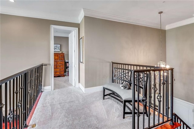 hallway featuring a notable chandelier, ornamental molding, and light colored carpet