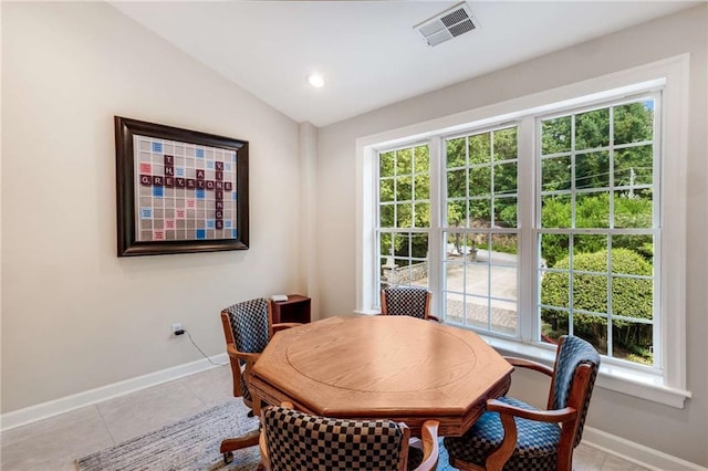 dining room featuring tile patterned flooring and vaulted ceiling