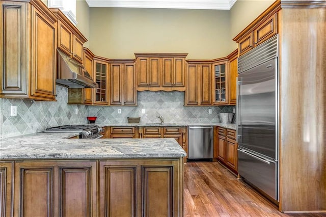 kitchen with tasteful backsplash, hardwood / wood-style floors, appliances with stainless steel finishes, sink, and ornamental molding