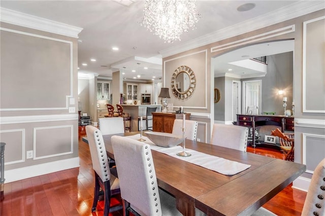 dining space with crown molding, a chandelier, and hardwood / wood-style floors