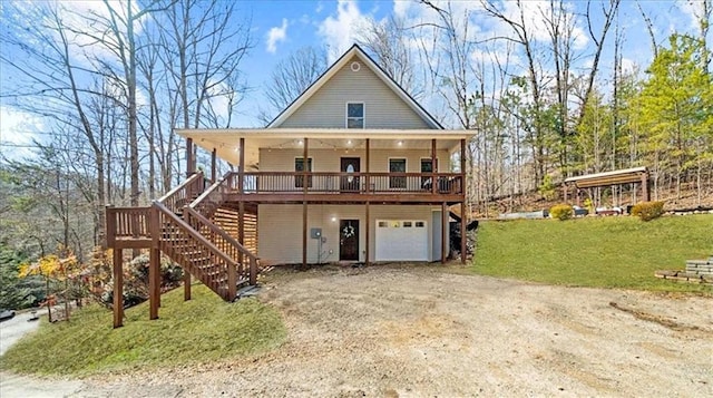 view of front of home featuring stairs, a front yard, an attached garage, and dirt driveway