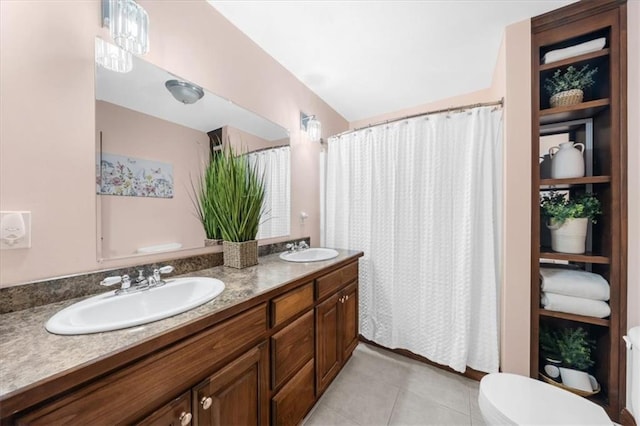 full bathroom featuring a sink, toilet, double vanity, and tile patterned floors