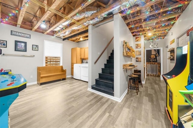 rec room featuring baseboards, light wood-style floors, and washing machine and dryer