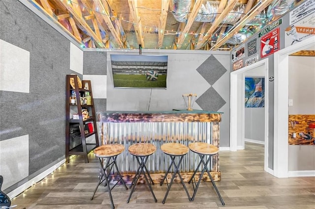 bar with baseboards and wood finished floors