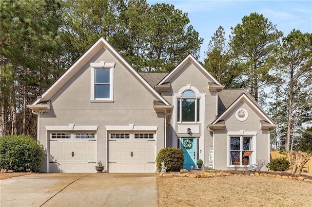 traditional-style home featuring stucco siding, concrete driveway, and a garage