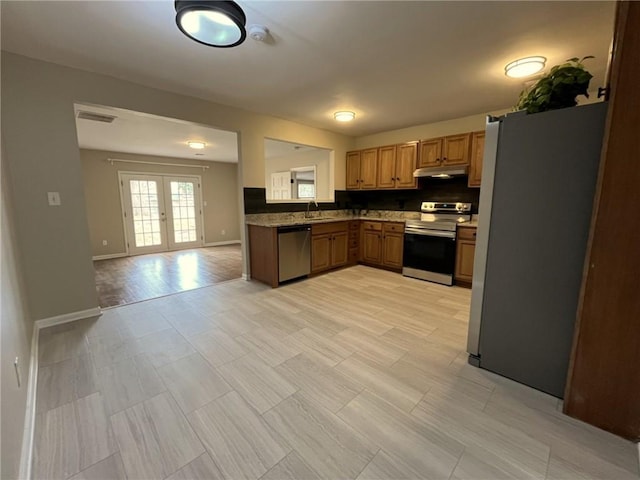 1929 Hazelwood Dr SE, Marietta, GA 30067 - kitchen with appliances with stainless steel finishes, under cabinet range hood, open floor plan, backsplash, and french doors