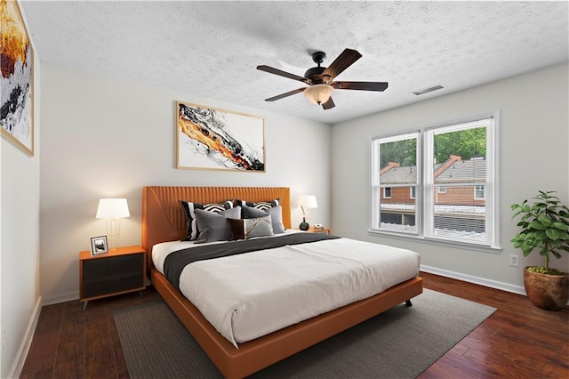 bedroom featuring baseboards, wood finished floors, a textured ceiling, and ceiling fan
