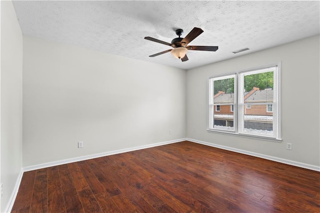 unfurnished room featuring ceiling fan, dark wood finished floors, baseboards, and a textured ceiling