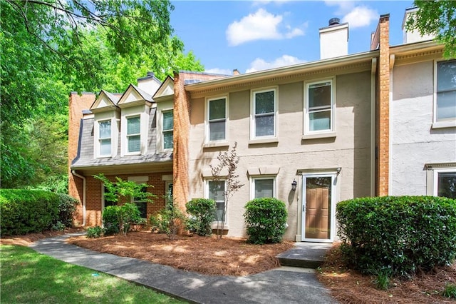 multi unit property featuring stucco siding and a chimney