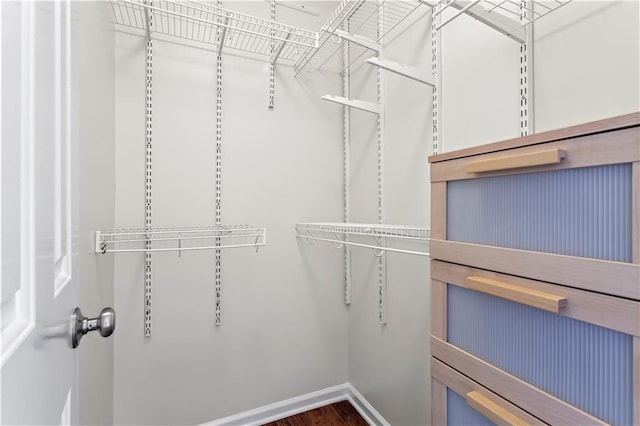 walk in closet with wood finished floors