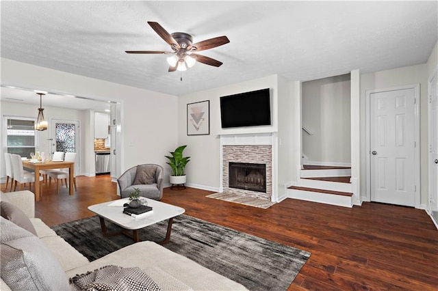 living room with ceiling fan, hardwood / wood-style floors, a fireplace, and baseboards