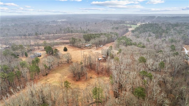 drone / aerial view featuring a view of trees and a rural view