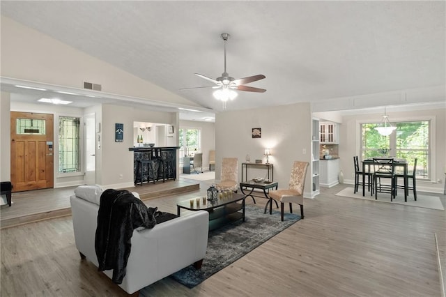 living room with wood-type flooring, a healthy amount of sunlight, ceiling fan, and vaulted ceiling