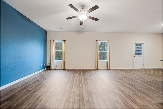 spare room featuring wood-type flooring, ceiling fan, and a healthy amount of sunlight