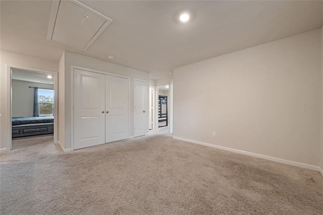 unfurnished bedroom featuring light colored carpet and a closet