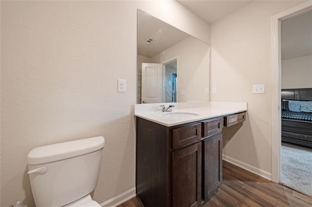 bathroom with hardwood / wood-style floors, vanity, and toilet