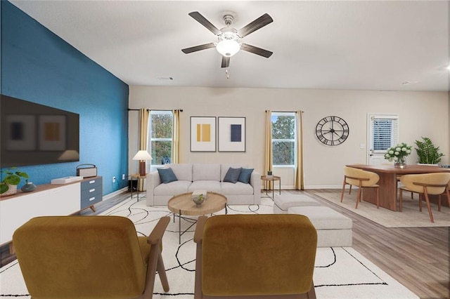 living room with ceiling fan, a healthy amount of sunlight, and light wood-type flooring