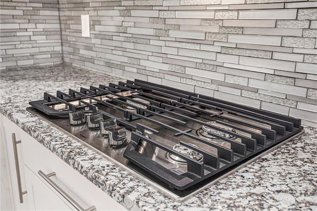 interior details with stainless steel gas cooktop and decorative backsplash