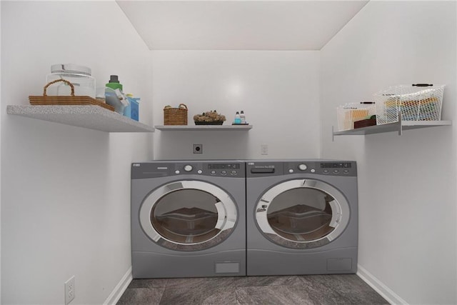 clothes washing area with washing machine and clothes dryer, laundry area, and baseboards