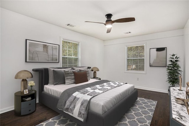 bedroom with a ceiling fan, wood finished floors, visible vents, and baseboards