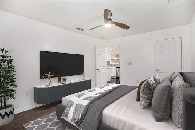 bedroom with visible vents, dark wood-type flooring, a ceiling fan, a sink, and baseboards