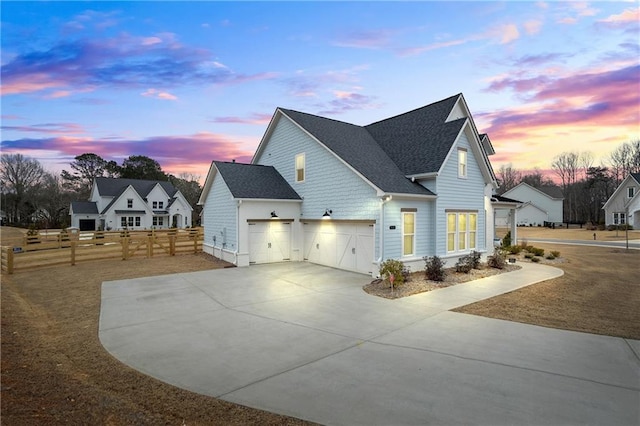 view of property exterior with roof with shingles, fence, and driveway