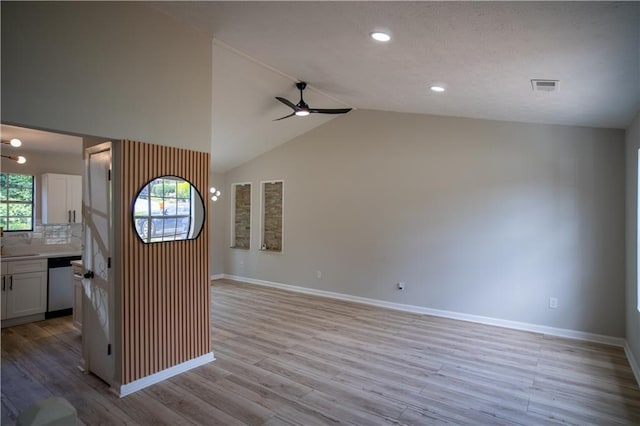 5072 Plantation View Trl, Stone Mountain, GA 30088 - kitchen with dishwasher, a ceiling fan, white cabinets, baseboards, and vaulted ceiling