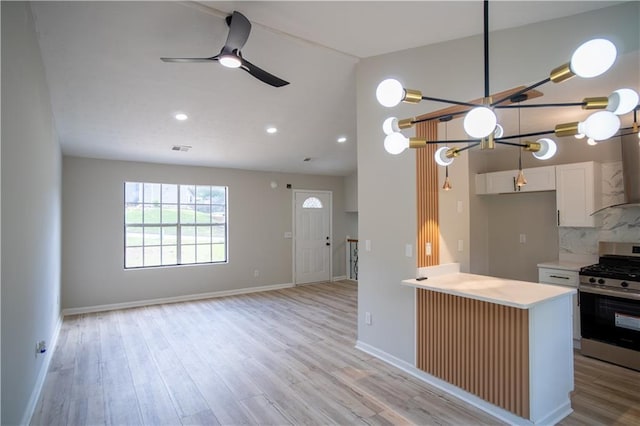 5072 Plantation View Trl, Stone Mountain, GA 30088 - kitchen with stainless steel range with gas cooktop, wall chimney range hood, light countertops, light wood-type flooring, and vaulted ceiling