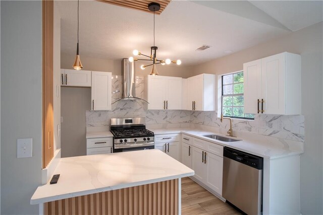 5072 Plantation View Trl, Stone Mountain, GA 30088 - kitchen featuring appliances with stainless steel finishes, ventilation hood, a sink, a peninsula, and light wood-style flooring