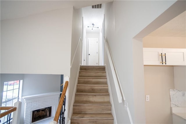 5072 Plantation View Trl, Stone Mountain, GA 30088 - stairway with wood finished floors and a brick fireplace