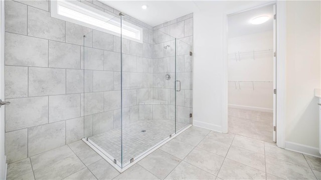 bathroom with a shower with shower door and tile patterned floors