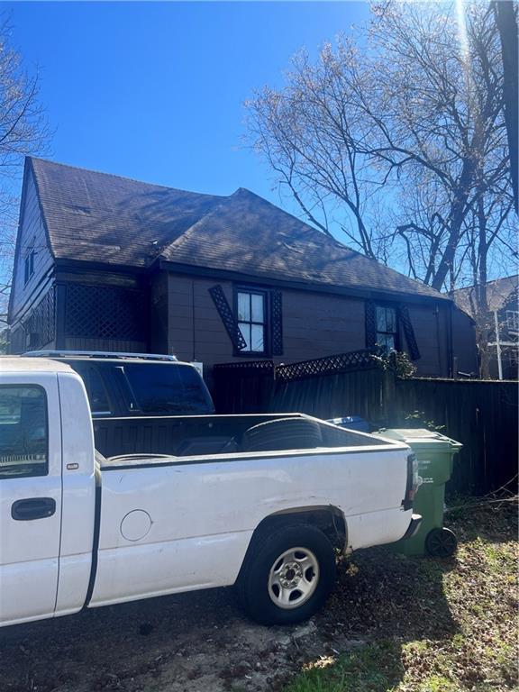 view of side of home with roof with shingles