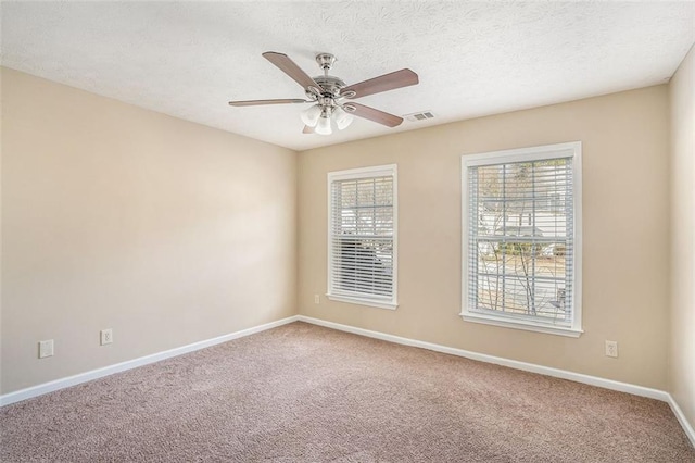 carpeted empty room featuring a textured ceiling and ceiling fan