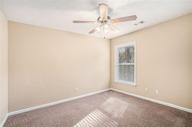 carpeted empty room with ceiling fan and a textured ceiling