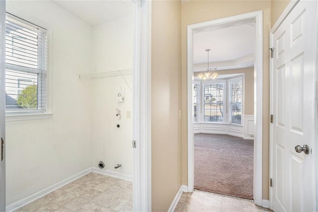 washroom featuring light colored carpet, crown molding, and a notable chandelier